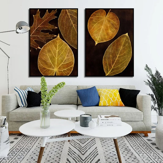 A captivating pair of botanical artworks depicting translucent leaf skeletons in golden-brown hues against a dark backdrop.