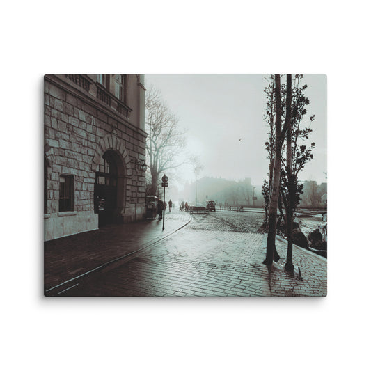 Foggy European plaza with wet cobblestone paving leading past a grand stone building with arched entrance.