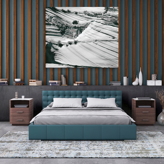 Black-and-white aerial view of dramatic, undulating sandstone layers carved by ancient water flows.